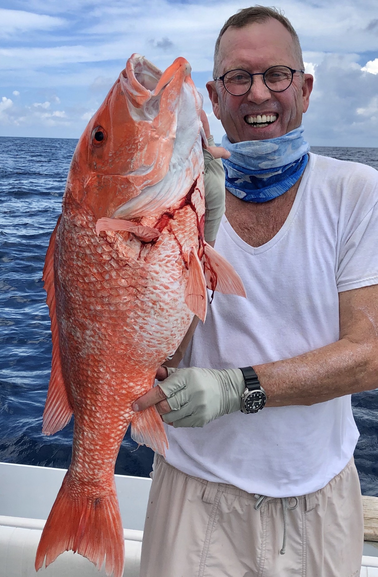 An angler displaying a large red fish