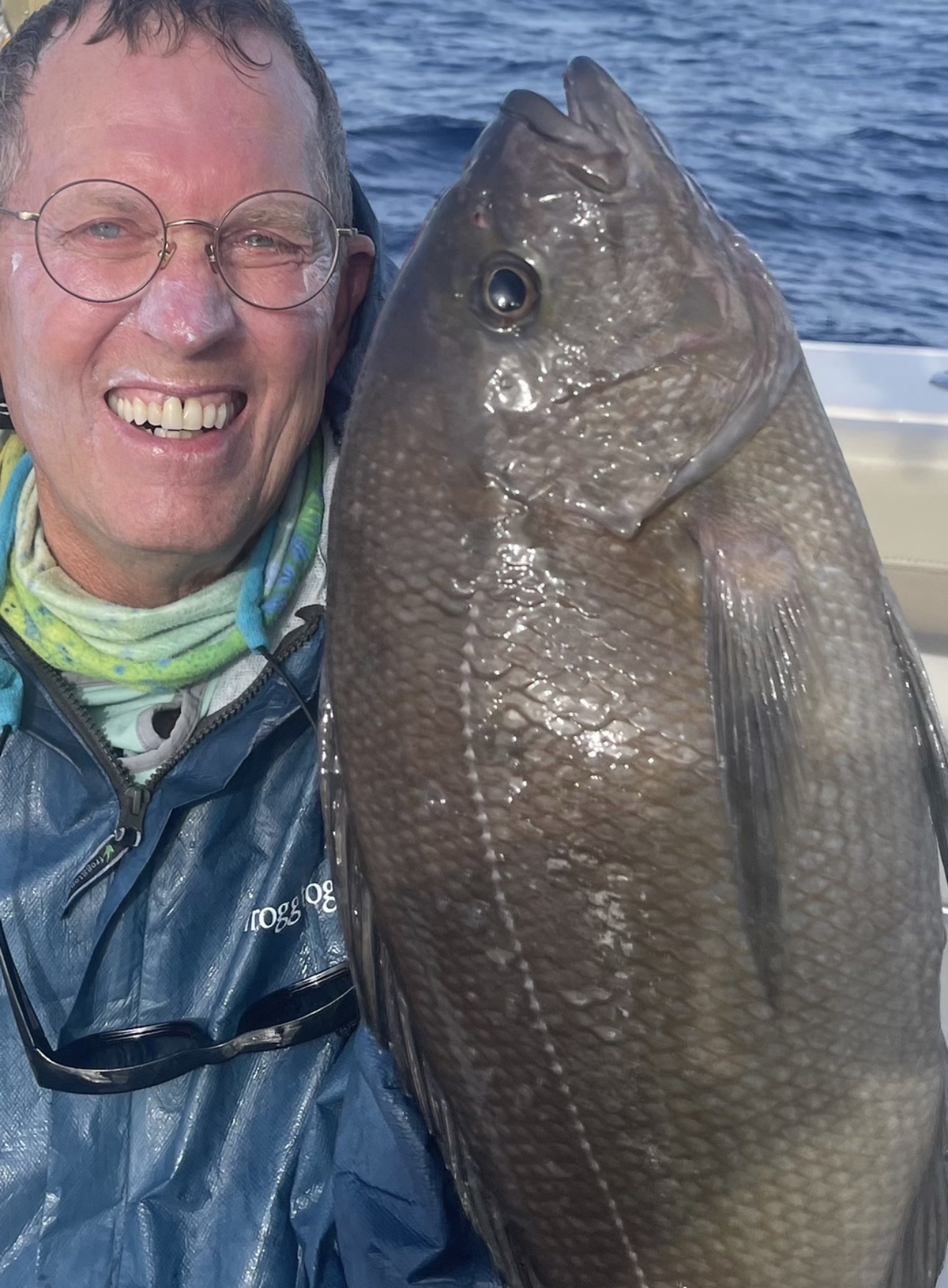 An angler holding a large dark fish